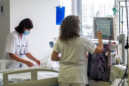Enfermeras preparan el puesto para otro paciente. T.A.