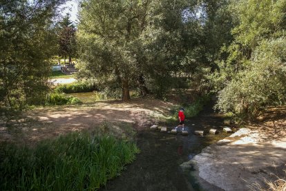 Un hombre cruza el río Arlanzón. TOMÁS ALONSO