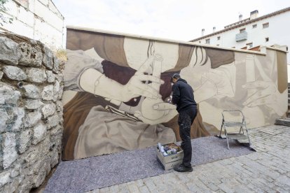 Christian Sasa trabaja en el mural del Callejón de las Brujas. SANTI OTERO