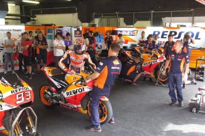 Marc Márquez se sube a su Honda, en el boxe del equipo Repsol Honda, en Montmeló.