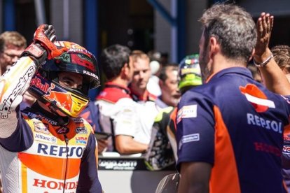 Marc Márquez y Javi Ortiz, uno de sus mecánicos, chocan sus cinco como celebración de la 'pole'.
