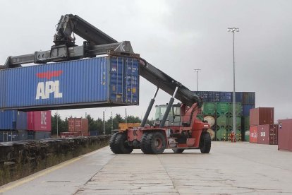 Una máquina mueve uno de los grandes contenedores que salen por ferrocarril desde el Puerto Seco de Burgos. / RAÚL G. OCHOA