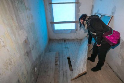 Cristina Fuentes muestra algunos daños en el suelo, consecuencia de las obras para cambiar el tejado. TOMÁS ALONSO