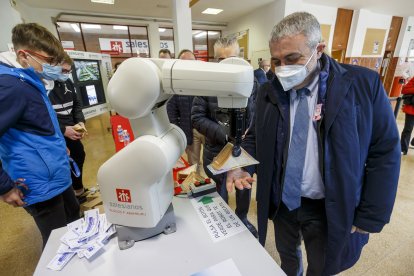 Un robot industrial se convirtió en un voluntario mas durante la Operación Bocata de Manos Unidas en el Padre Aramburu. En la imagen entrega un bocadillo al subdelegado del Gobierno, Pedro de la Fuente. SANTI OTERO