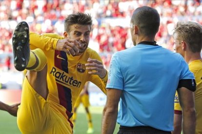 Piqué trata de convencer al árbitro de que no hizo penalti ante Osasuna