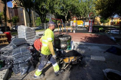 Dos operarios, ayer en la reparación de un parque infantil en la Barriada Inmaculada. SANTI OTERO