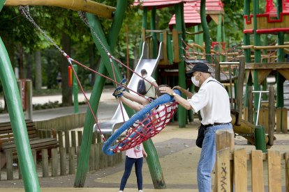 Un abuelo columpia a sus nietos en La Isla.