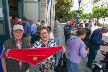 Una mujer sonríe tras haber conseguido su pañuelo después de hace cola.