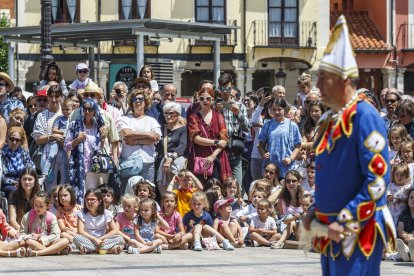 Los niños sentados en el suelo para ver el baile de los danzantes con un tetín en primer plano.