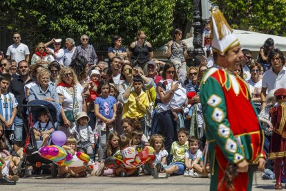 Los niños sentados en el suelo para ver el baile de los danzantes con un tetín en primer plano.