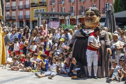 Los niños sentados en el suelo para ver el baile de los danzantes con la gigantilla en el centro.