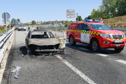 Bomberos de Burgos y Guardia Civil junto al vehículo siniestrado.