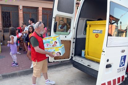 Un voluntario de Cruz Roja guarda unas cajas de pañales donados en Agés en una furgoneta.