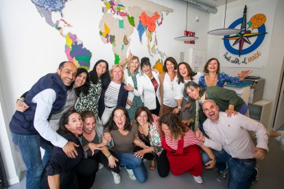 La plantilla al completo de Burgos Acoge posa divertida en su nueva sede, bajo un mapa del mundo inundado de color.