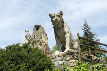 Escultura del perro con el pastor al fondo.