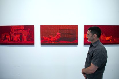 Garcerá contempla sus obras sobre seda de intenso color rojo.