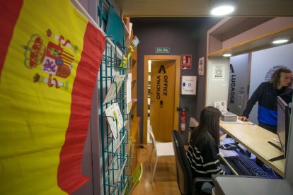 La recepcionista atiende a un usuario del Hostel Burgos.