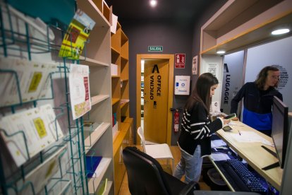 La recepcionista atiende a un usuario del Hostel Burgos.