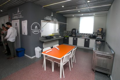 Zona de cocina a disposición de los clientes con espacio de mesas y sillas.