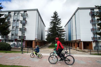 Una familia pasea en bicicleta por una de las calles del barrio.
