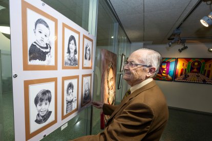 Martín de Frutos cuelga algunos de sus retratos de niños.