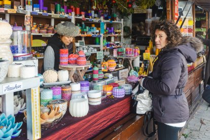 Una mujer compra velas en uno de los 28 puestos del mercado.