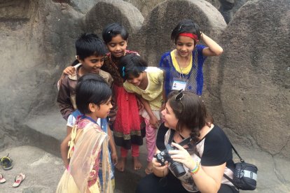 Olga enseña una fotografía a un grupo de niños.