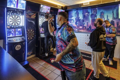 Un jugador echa una partida de dardos en Top Tren.