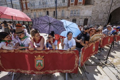 Unos pocos valientes que acudieron a ver el acto se cubren con paraguas del sol.