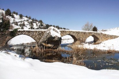 Imagen del puente romano nevado.