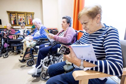Un grupo de abuelas lee con detenimiento las tarjetas nada más recibirlas.