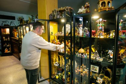 Fernando Gutiérrez y su padre muestran algunas de las piezas de su colección de 250 belenes, reunida a lo largo de los años y expuesta cada Navidad en un cuidado montaje familiar.