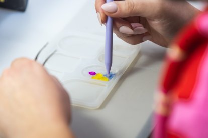 María confecciona una jota de resina y flores.