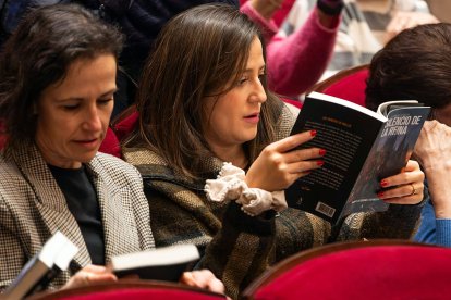 Dos lectoras ojean 'El silencio de la Reina' antes del acto.
