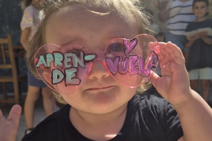 Una niña posa con unas gafas hecha en los talleres.