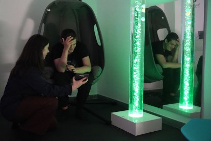 Sara Hernando, terapeuta ocupacional del Centro San Juan de Dios de Valladolid junto a Miguel, usuario del centro, en la sala multisensorial en el Centro San Juan de Dios de Valladolid