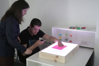 Sara Hernando, terapeuta ocupacional del Centro San Juan de Dios de Valladolid junto a Miguel, usuario del centro, en la sala multisensorial en el Centro San Juan de Dios de Valladolid