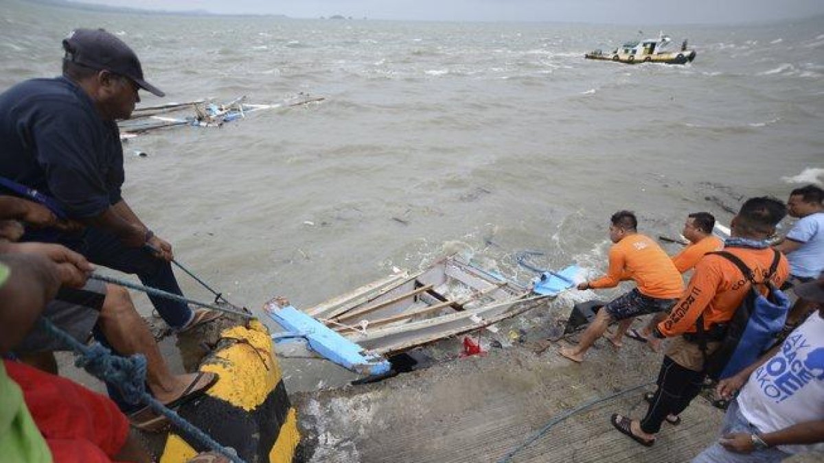 Miembros de la Guardia Costera de Filipinas transportan los restos de un barco.-EPA