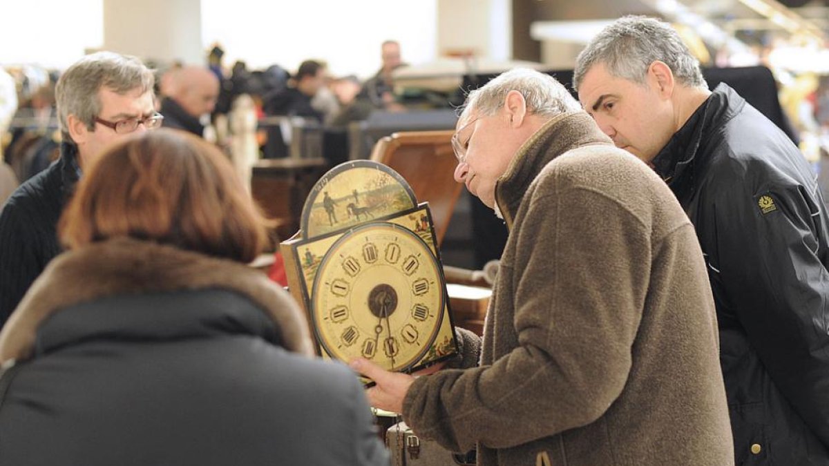 Dos hombres obervan un reloj en una de las ediciones de la feria.-ISRAEL L. MURILLO