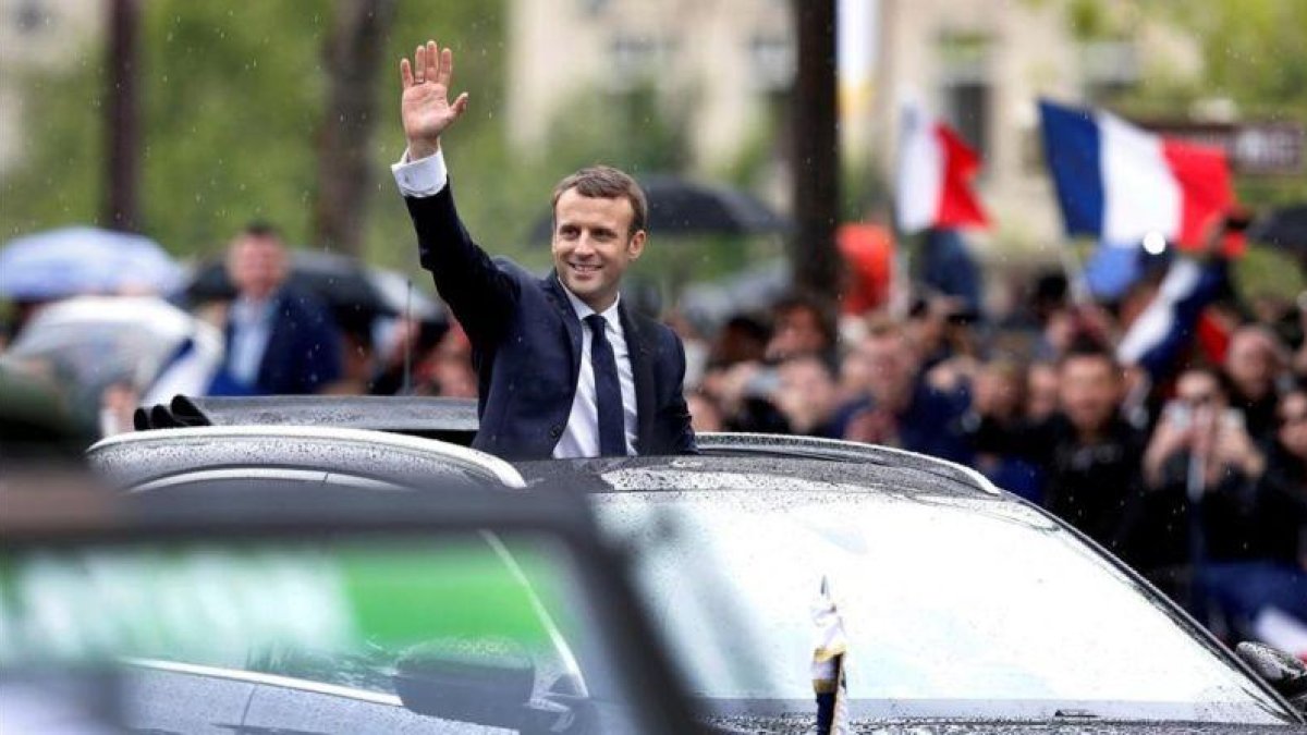 Macron saluda a la multitud desde su coche presidencial en París.-FRANÇOIS LENOIR / REUTERS