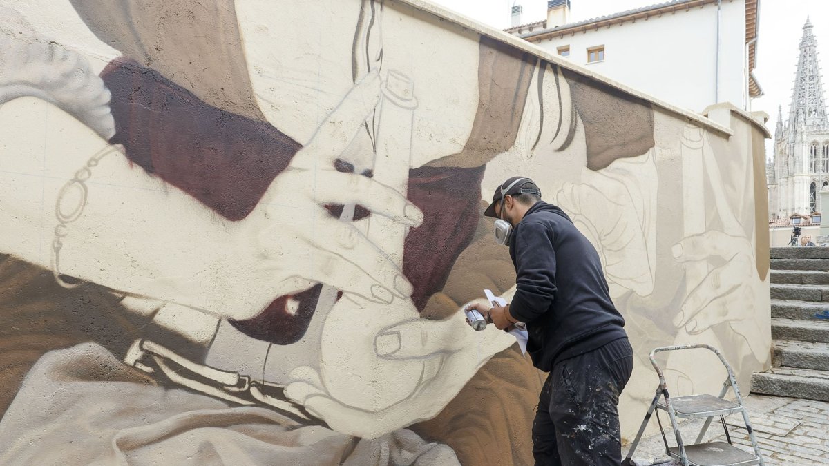 Christian Sasa trabaja en el mural del Callejón de las Brujas. SANTI OTERO