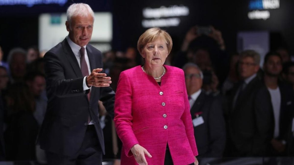 Merkel (derecha) y Matthias Mueller, presidente de Volkswagen, en el Salón Internacional del Automóvil de Fráncfort, el 14 de septiembre.-/ GETTY IMAGES / SEAN GALLUP