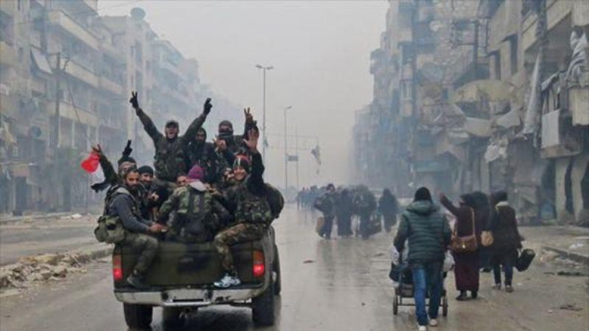 Combatientes progubernamentales hacen la señal de la victoria, ayer en una calle de Alepo.-AFP