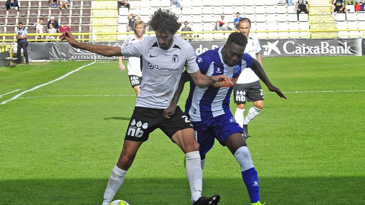 Carlos Martínez protege un balón frente a un delantero del Alavés B-Israel L. Murillo