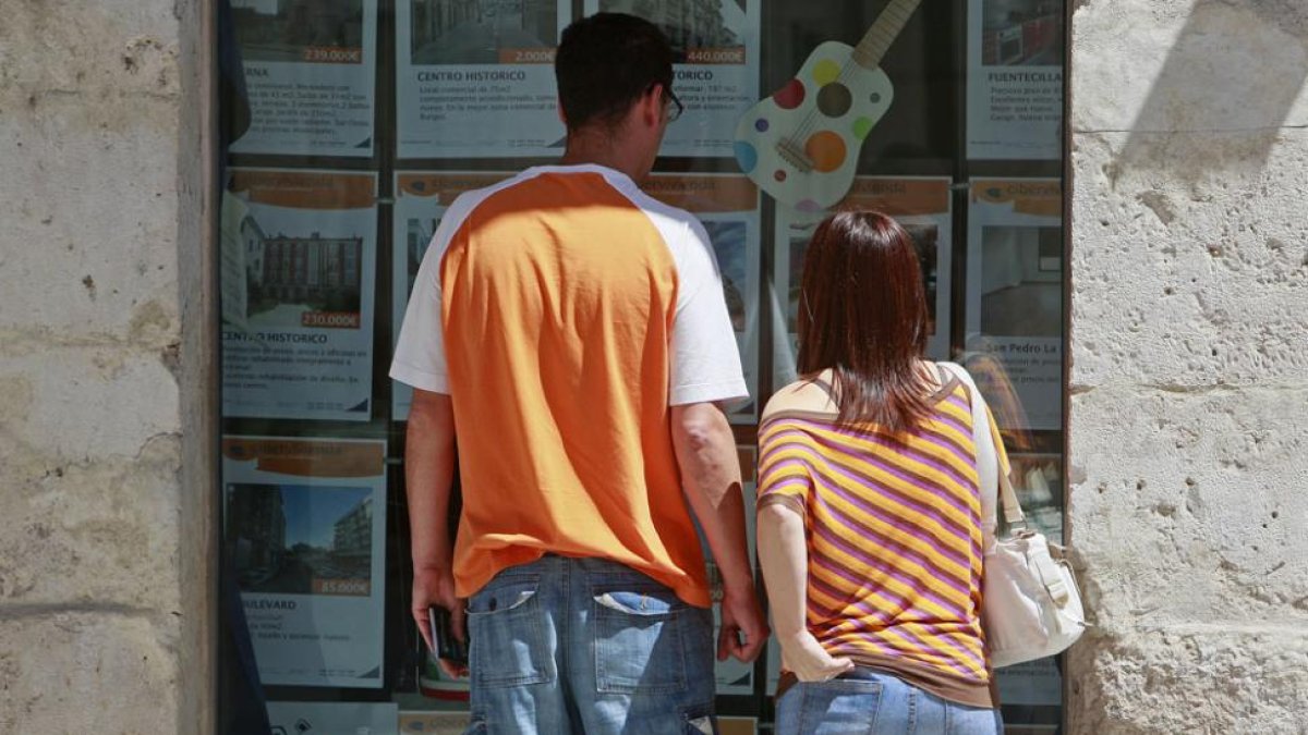 Una pareja observa anuncios de pisos de una inmobiliaria.-RAÚL G. OCHOA