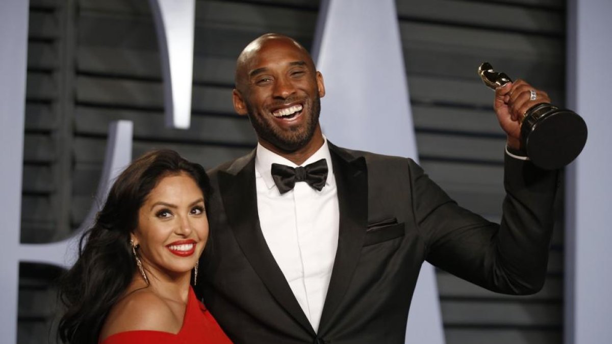 Kobe Byrant, junto a su mujer Vanessa, sostiene el Oscar a la entrada de la fiesta de Vanity Fair-/ DANNY MOLOSHOK (REUTERS)