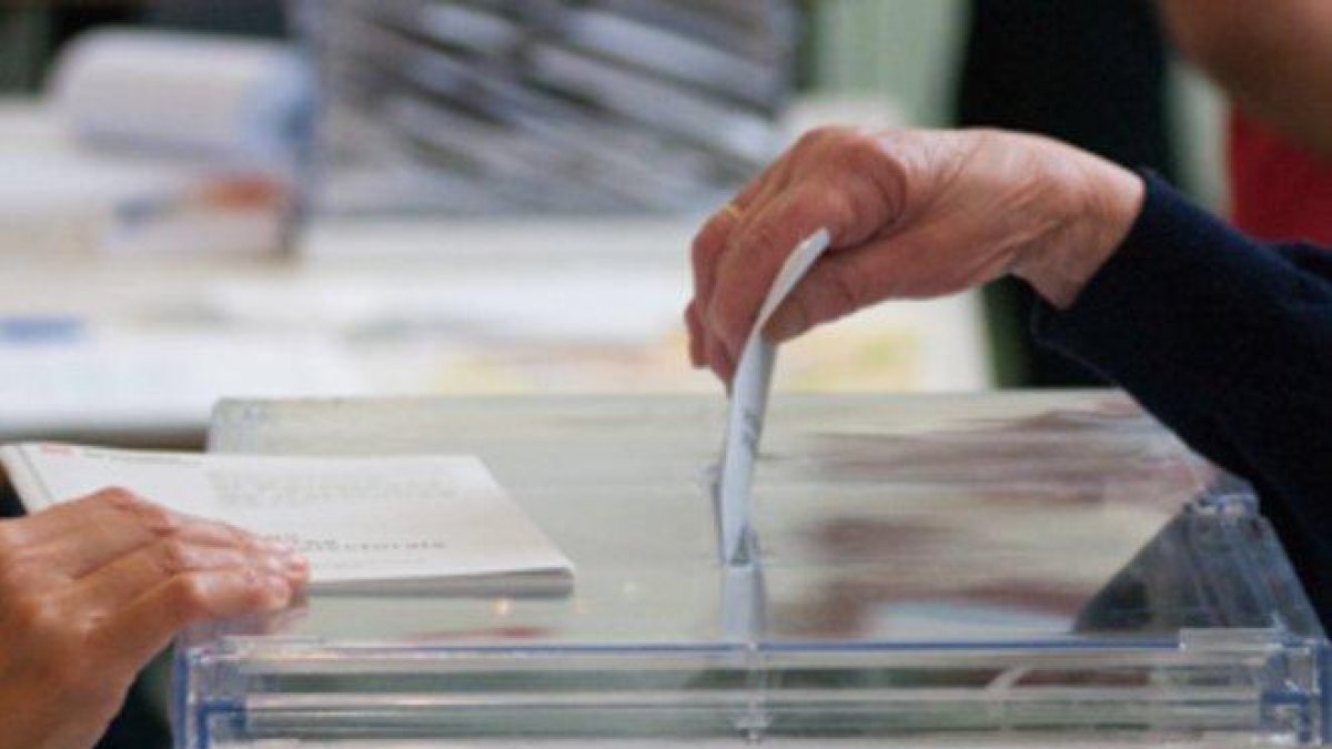 Una ciudadana introduciendo su voto en la urna.-