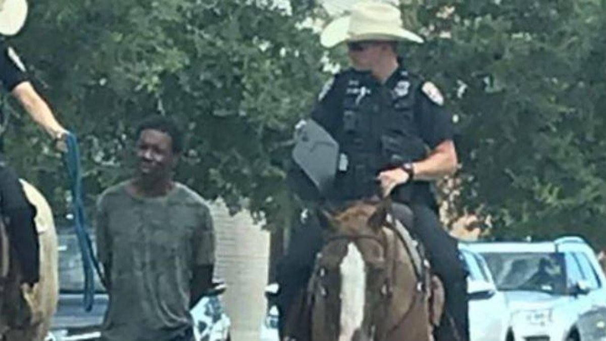 La imagen de la polémica: dos policías montados a caballo trasladan a un hombre negro atado con una cuerda, en Galveston (Texas).-