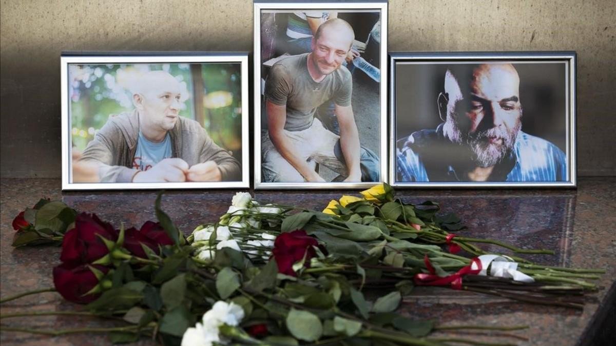 Ofendas florales ante las fotografías de los 3 periodistas rusos asesinados, ante la sede de la Unión Rusa de Periodistas, en Moscú.-PAVEL GOLOVKIN