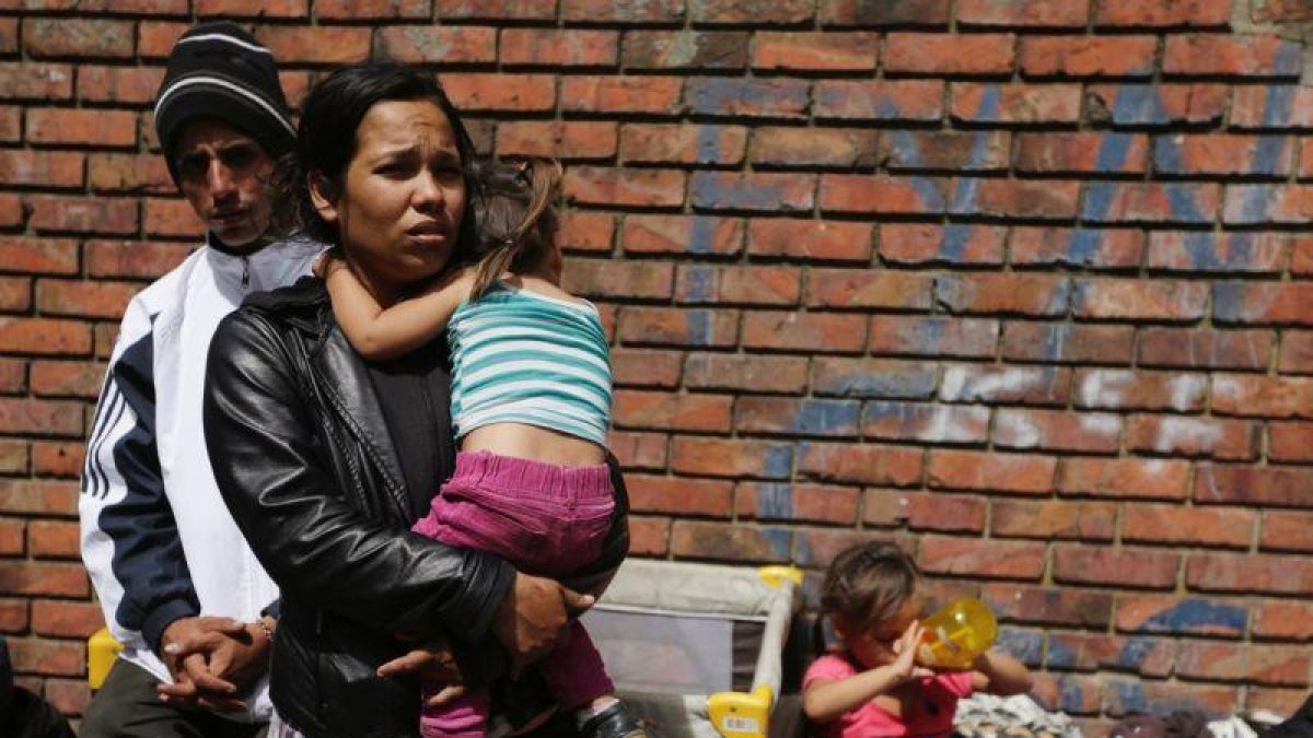 Llevando a su bebé en brazos en un campo de refugiados venezolanos en Colombia.-REUTERS